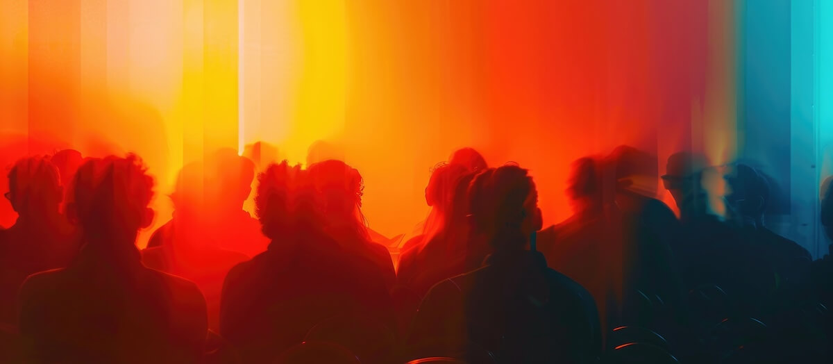 Vibrant abstract scene with blurred silhouettes of people against warm orange and red lights